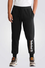 TIMBERLAND - מכנסי טרנינג עם הדפס לוגו המותג על הרגל בתחתית - MASHBIR//365