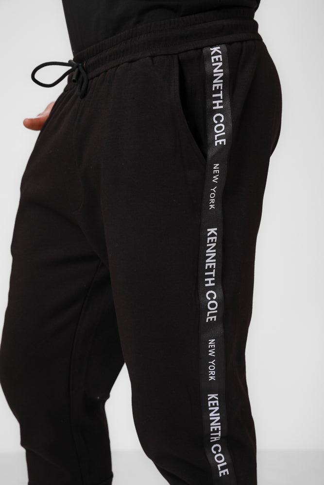 KENNETH COLE - מכנסי טרנינג עם פס כיתוב לוגו בצבע שחור - MASHBIR//365