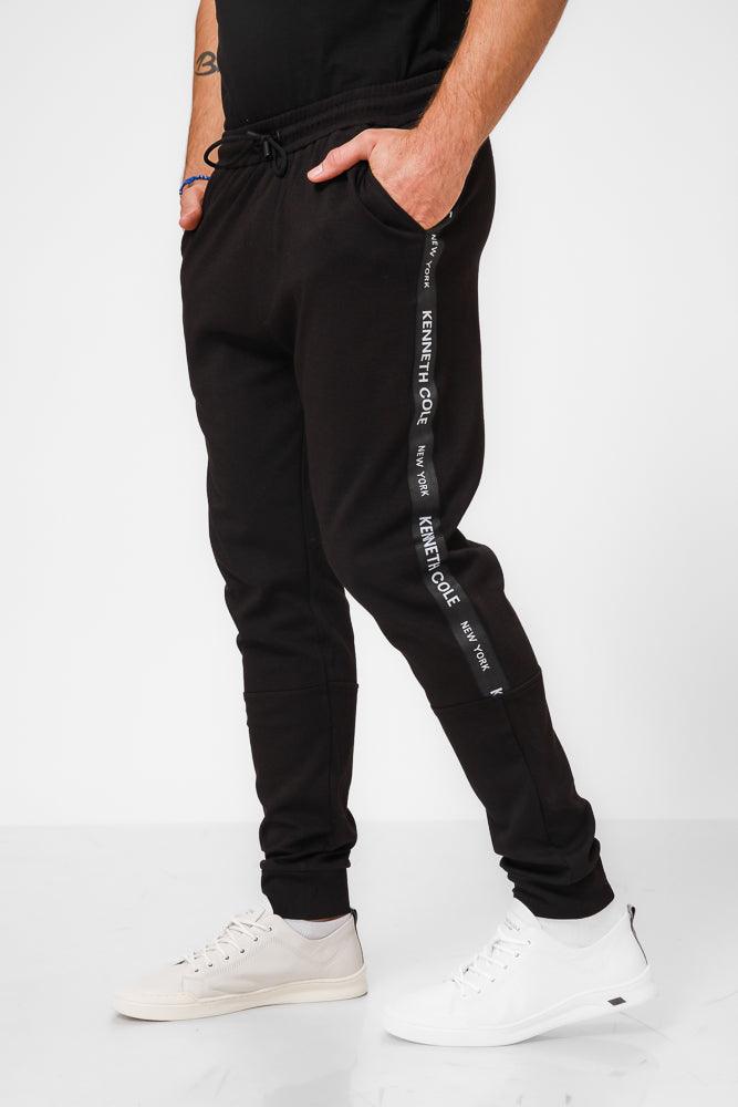 KENNETH COLE - מכנסי טרנינג עם פס כיתוב לוגו בצבע שחור - MASHBIR//365