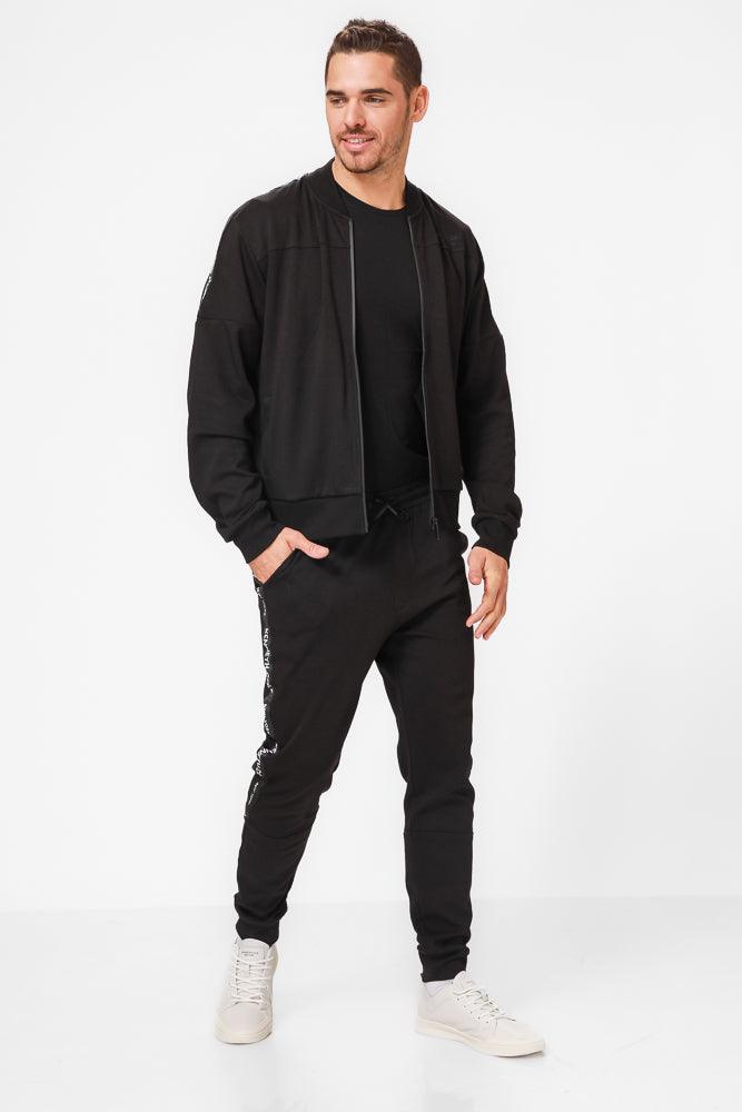 KENNETH COLE - מכנסי טרנינג עם פס כיתוב לוגו בצבע שחור - MASHBIR//365